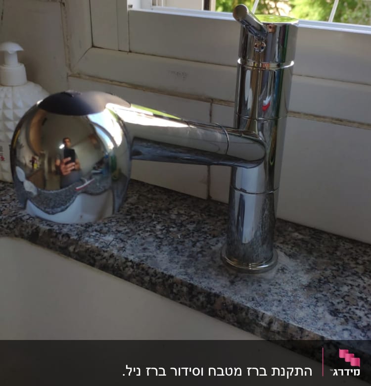 ברז מטבח מתכתי על משטח גרניט